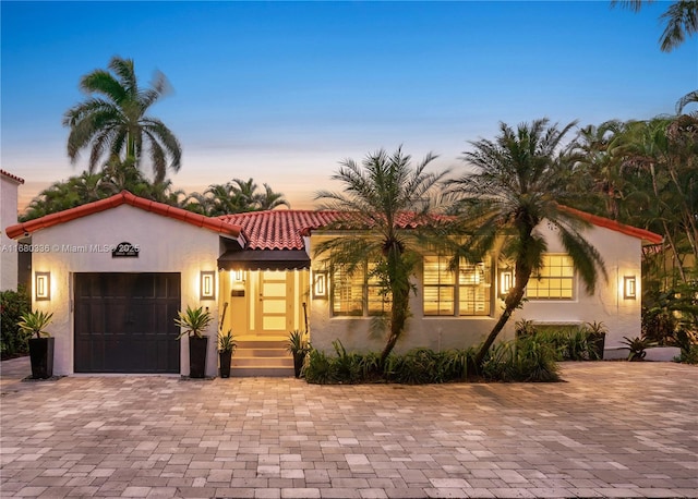 mediterranean / spanish home featuring a garage