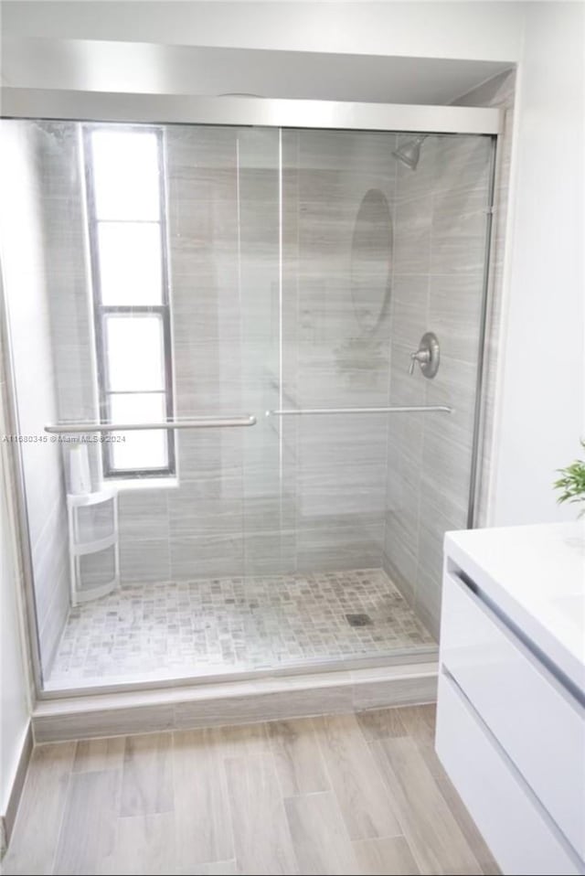 bathroom with vanity, a shower with door, and hardwood / wood-style floors