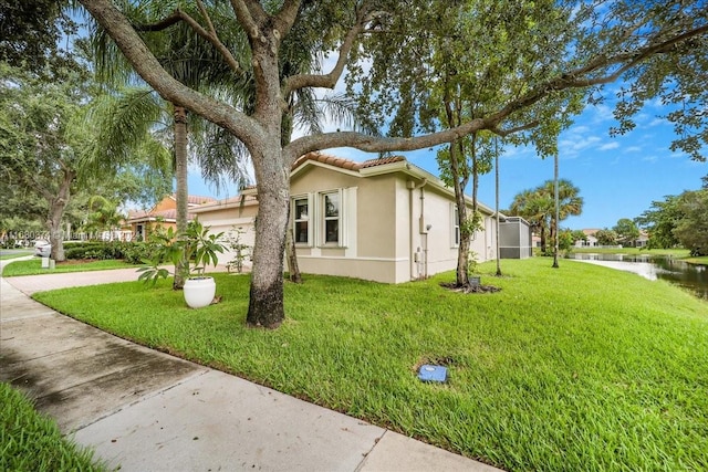 view of home's exterior with a yard and a water view