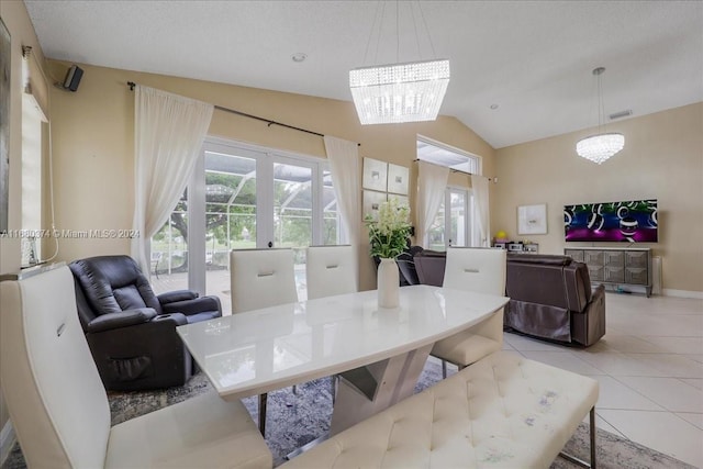 tiled dining space featuring a textured ceiling, a healthy amount of sunlight, vaulted ceiling, and an inviting chandelier