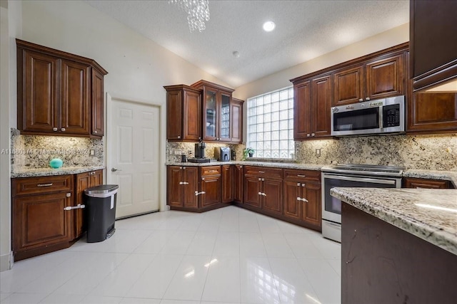 kitchen featuring stainless steel appliances, lofted ceiling, and backsplash