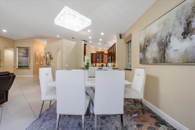 dining space with lofted ceiling and light tile patterned floors