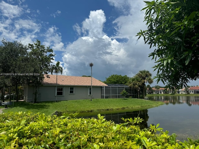 view of yard featuring glass enclosure and a water view