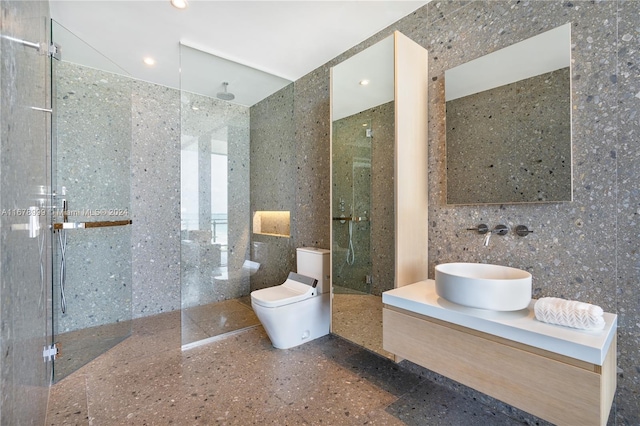 bathroom featuring toilet, walk in shower, vanity, and tile walls