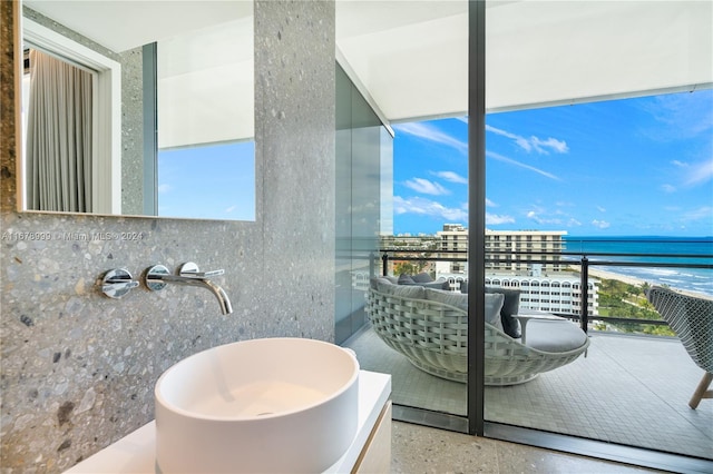 balcony with sink and a water view