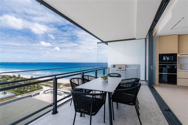 balcony featuring a water view and a beach view