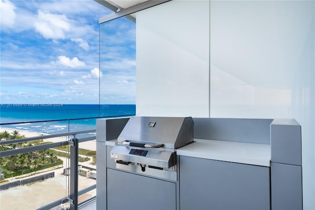 balcony with grilling area, a water view, and a beach view