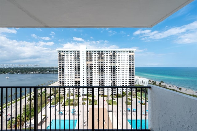 balcony with a water view and a view of the beach