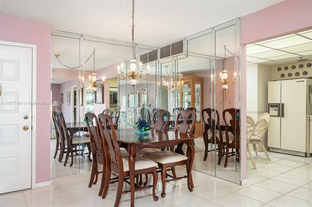 dining space with a notable chandelier and light tile patterned flooring