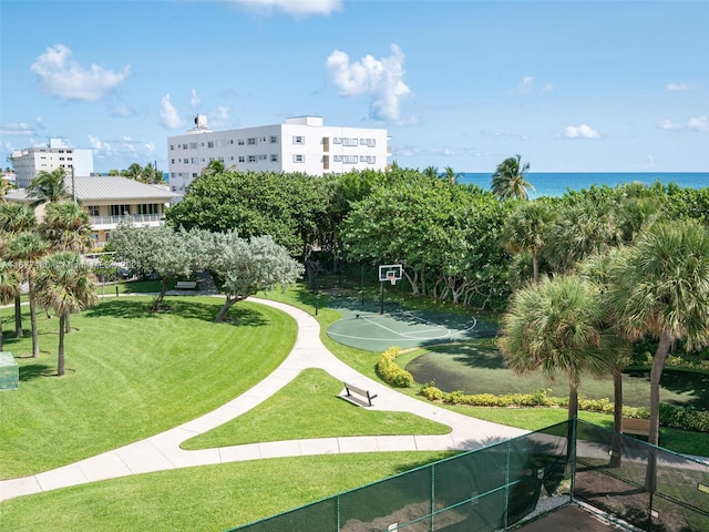 view of property's community with a water view, a lawn, and basketball court