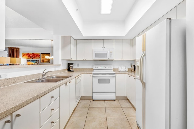 kitchen featuring light tile patterned floors, white appliances, a sink, light countertops, and a tray ceiling