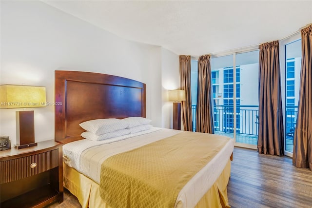 bedroom featuring access to outside, expansive windows, wood finished floors, and multiple windows