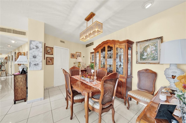 dining space featuring light tile patterned flooring and an inviting chandelier