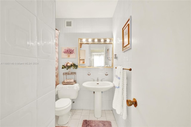 2451 Brickell Ave Unit 17G, Miami, FL 33129 - bathroom featuring toilet, tile walls, tile patterned floors, and a sink