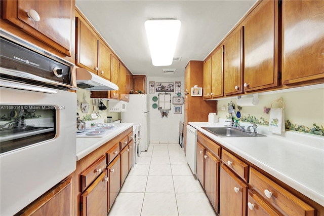 kitchen featuring sink, light tile patterned floors, and white appliances