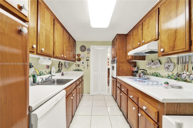 kitchen with white appliances, light tile patterned floors, and sink