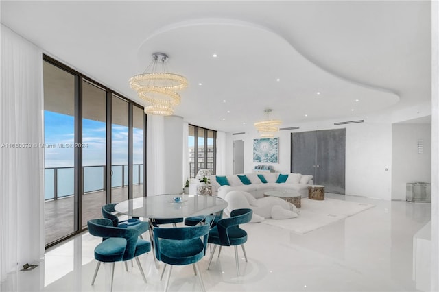 dining space featuring a water view, a notable chandelier, and floor to ceiling windows