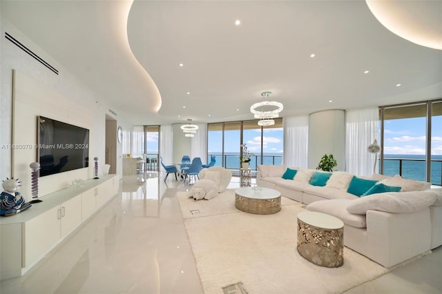 living room with a chandelier, a water view, and floor to ceiling windows