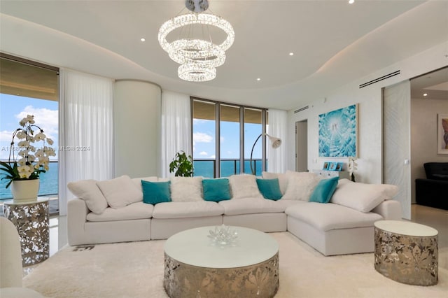 living room with a water view, an inviting chandelier, and plenty of natural light