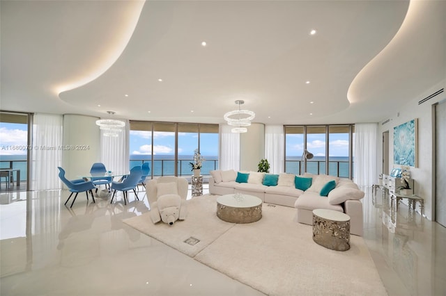 living room featuring an inviting chandelier, a water view, and floor to ceiling windows