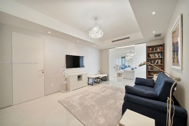 living room with a notable chandelier and a raised ceiling