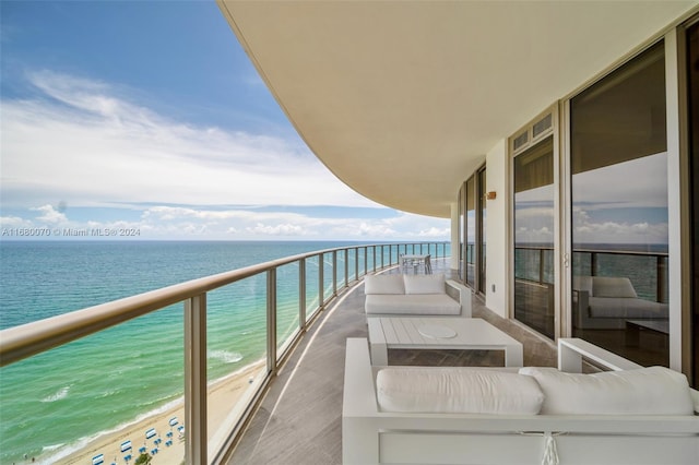 balcony featuring a water view and a view of the beach