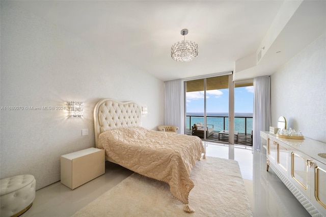 bedroom with a water view, an inviting chandelier, a wall of windows, and access to exterior