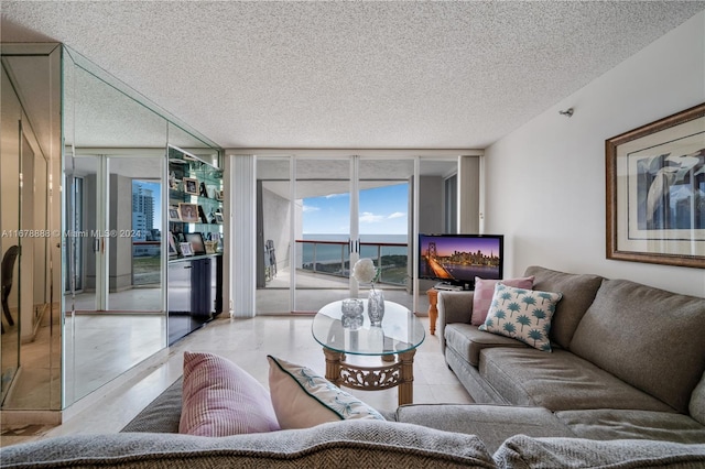 living room with a textured ceiling and floor to ceiling windows