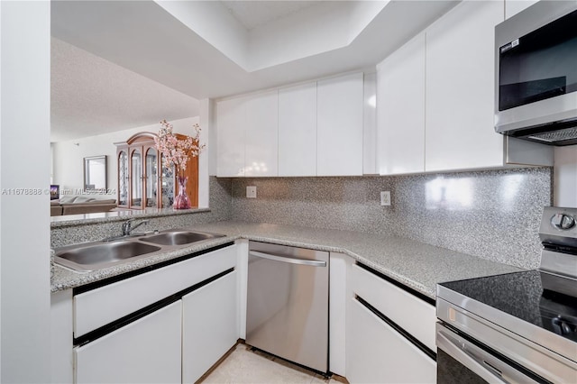 kitchen with white cabinetry, appliances with stainless steel finishes, sink, and decorative backsplash