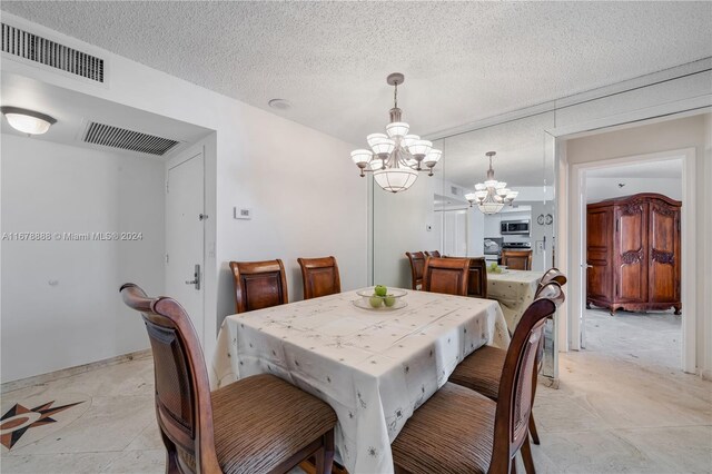 dining space with a notable chandelier and a textured ceiling