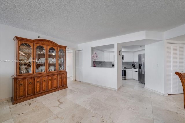 6767 Collins Ave Unit 602, Miami Beach, FL 33141 - interior space featuring a textured ceiling and baseboards