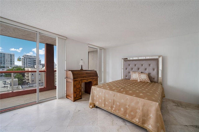 bedroom with a wall of windows, a textured ceiling, and access to exterior