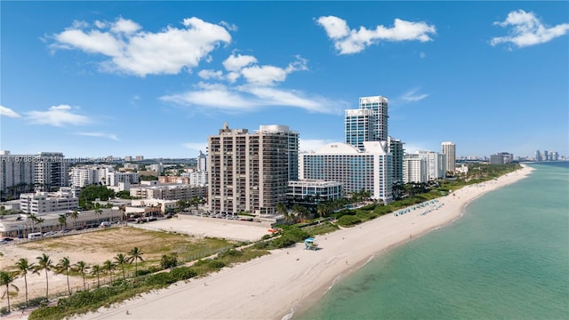 birds eye view of property with a water view and a beach view