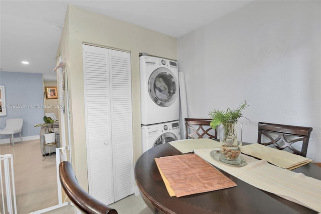 tiled dining space featuring stacked washer / dryer