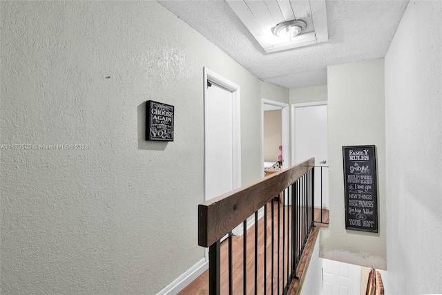 hallway featuring a textured ceiling and hardwood / wood-style flooring