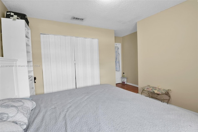 bedroom featuring a closet, a textured ceiling, and carpet floors