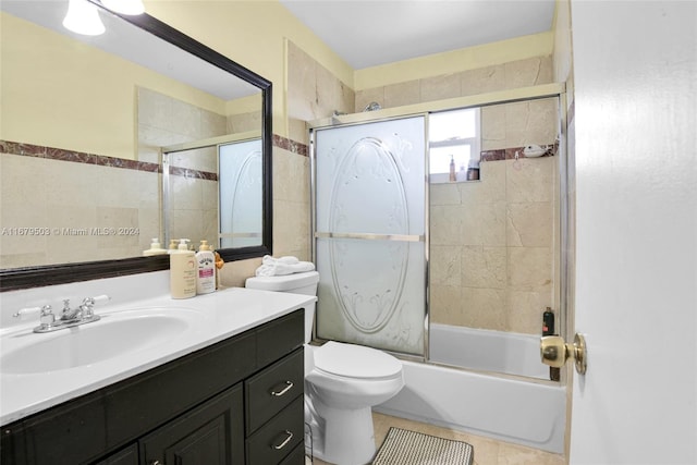 full bathroom featuring vanity, toilet, shower / bath combination with glass door, and tile patterned flooring