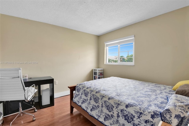 bedroom featuring a textured ceiling and wood-type flooring