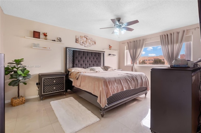 bedroom with ceiling fan, a textured ceiling, and light tile patterned floors