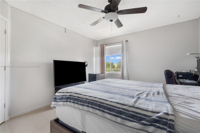 bedroom with ceiling fan and a textured ceiling