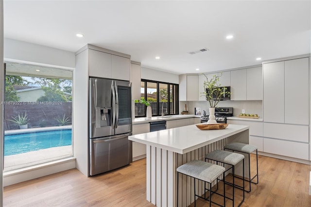 kitchen with light hardwood / wood-style flooring, stainless steel appliances, and a kitchen island