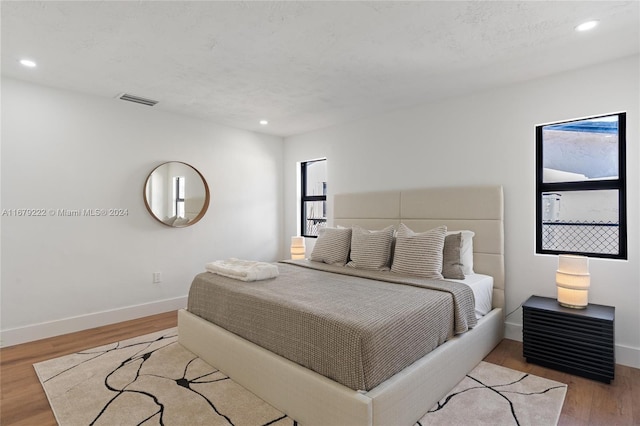 bedroom featuring a textured ceiling and light wood-type flooring