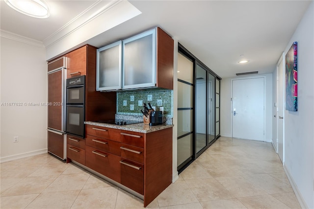 kitchen featuring decorative backsplash, light stone countertops, light tile patterned flooring, crown molding, and double oven