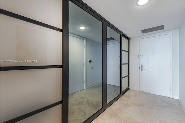 hall with light tile patterned floors