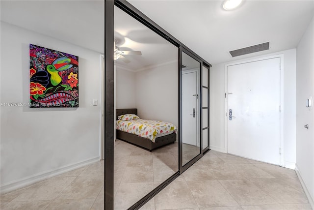 tiled bedroom featuring crown molding and ceiling fan