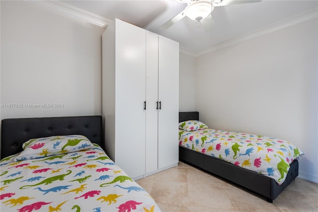 tiled bedroom with ornamental molding and ceiling fan