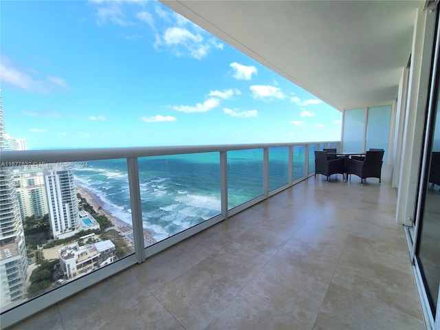 balcony with a water view and a view of the beach