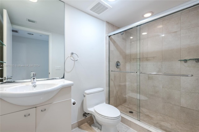 bathroom featuring vanity, a shower with shower door, toilet, and tile patterned flooring