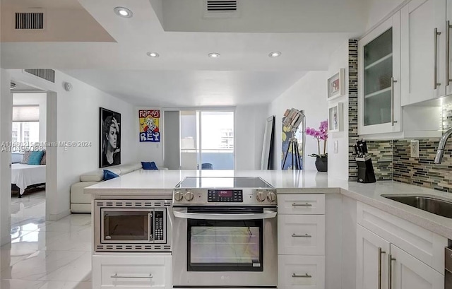 kitchen featuring sink, appliances with stainless steel finishes, decorative backsplash, and white cabinets