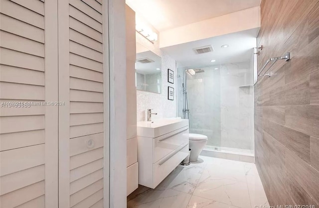 bathroom featuring vanity, toilet, and tiled shower